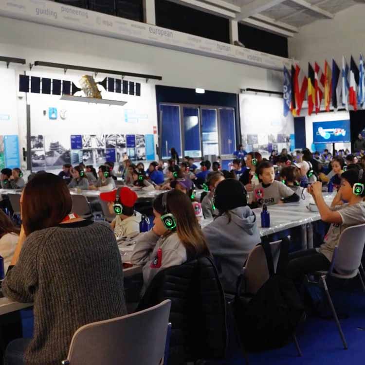 scuola-esa Étudiants avec casques sans fil dans un grand amphithéâtre pendant un cours